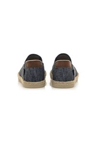 Scarpe slip-on in tessuto blu navy con una trama intrecciata e dettagli in pelle marrone; la suola avvolta in juta offre una finitura naturale.