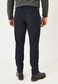 Marineblaue, maßgeschneiderte Hose mit glatter Textur, dezentem Webmuster, zwei Gesäßtaschen mit Knöpfen und schlanker Passform.