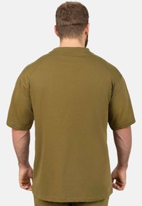 Maglietta verde oliva a maniche corte con scollatura rotonda, texture liscia e maniche raglan, mostrata da dietro.