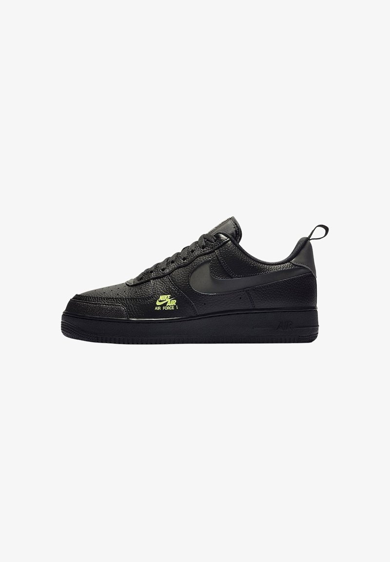 Zwarte Nike Air Force 1 sneaker met getextureerd leer, zwarte swoosh, veters aan de voorkant en klein neon geel "Nike Air Force 1" logo aan de zijkant.