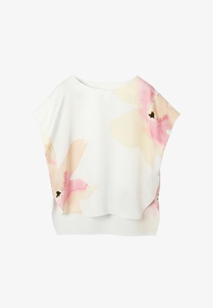 Blouse blanche à manches courtes, coupe ample, avec de grands imprimés floraux rose pâle et beige sur le devant et les épaules.