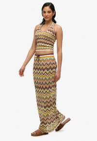 Mehrfarbiges Zickzack-Muster-Set bestehend aus einem enganliegenden Halter-Crop-Top und einem langen, fließenden Rock mit verstellbarem Kordelzugbund.