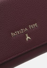 Bordeaux nahka-lompakko, jossa on teksturoitu pinta, kultasävyisellä "Patrizia Pepe" -logolla ja pienellä emblemiyksityiskohdalla.