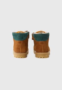 Botine din suede maro cu un tiv superior teal, fermoar lateral și talpă din cauciuc texturată, având o căptușeală moale pentru confort.