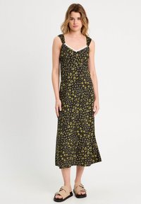 Schwarzes Maxikleid mit floralen Mustern in Gelb und Weiß, mit breiten Trägern und einer mit Spitze verzierten Halslinie. Lockere Passform und knielange Länge.