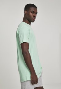 Myntegrønne bomulds t-shirt med rund hals, korte ærmer og en afslappet pasform. Stoffet har en glat tekstur og et let udseende.