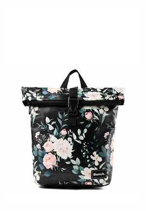 Schwarzer Roll-Top Rucksack mit pink-weißem Blumenmuster, schwarzer Schnallenverschluss, Tragegriff und Bench Markenetikett vorne.