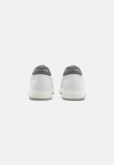Baskets blanches avec un onglet de talon gris et un branding "FILLING PIECES". Tige en cuir lisse avec des accents texturés. Semelle en caoutchouc épaisse.