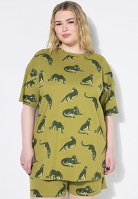 Set di maglietta oversize verde e pantaloni corti con un motivo ripetuto di gatti neri e bianchi. Tessuto morbido, vestibilità rilassata, con maniche corte.