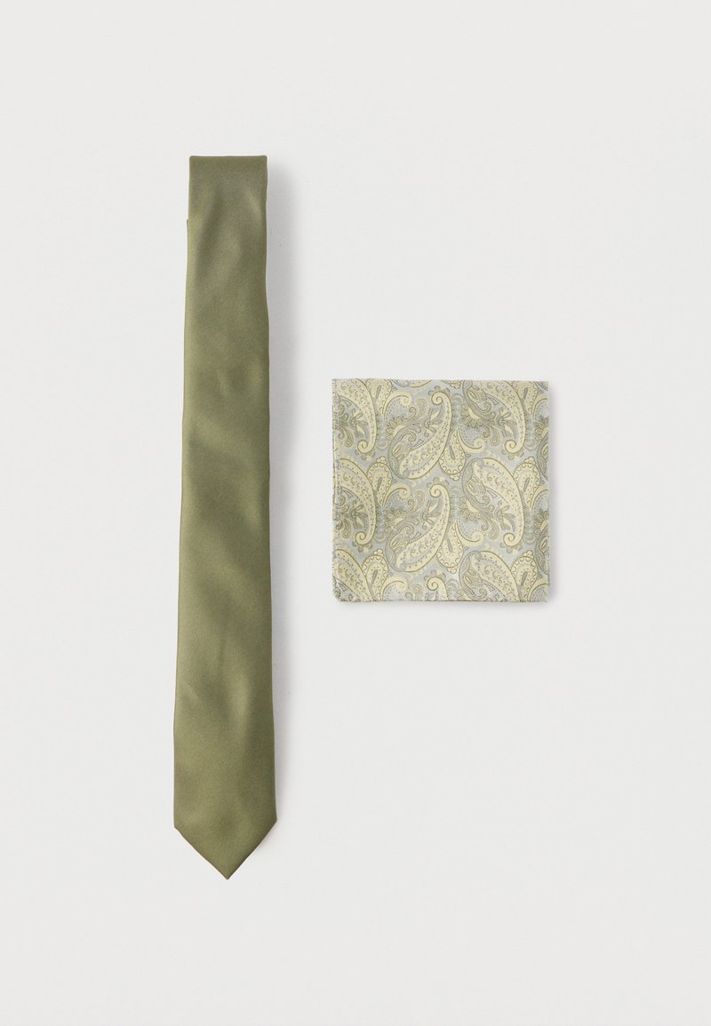 Γραβάτα σε σταθερό ελαιί πράσινο μετάξι, σε συνδυασμό με μαντηλάκι τσέπης που διαθέτει μπεζ και γκρι σχέδιο παϊλέ σε λευκό φόντο.