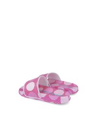 Sandalias de diapositiva rosa con una superficie texturizada y grandes lunares blancos, con doble correa y una suela flexible.