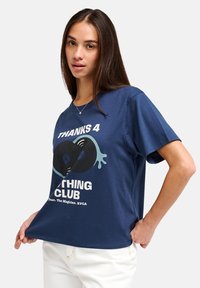 Μπλε ναυτικό βαμβακερό μπλουζάκι με κοντά μανίκια, με γραφικό σχέδιο από βινύλια και κείμενο "THANKS 4 THING CLUB" σε λευκό και πράσινο.