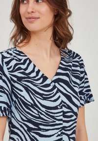 Kratka obleka s kratkimi rokavi in V-izrezom, ki ima modro in mornarsko zebraste črte, lahkotno blago in gumbne dodatke spredaj.