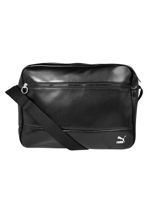 Sac bandoulière rectangulaire noir avec poche avant zippée, bandoulière ajustable et logo Puma blanc dans le coin inférieur droit.