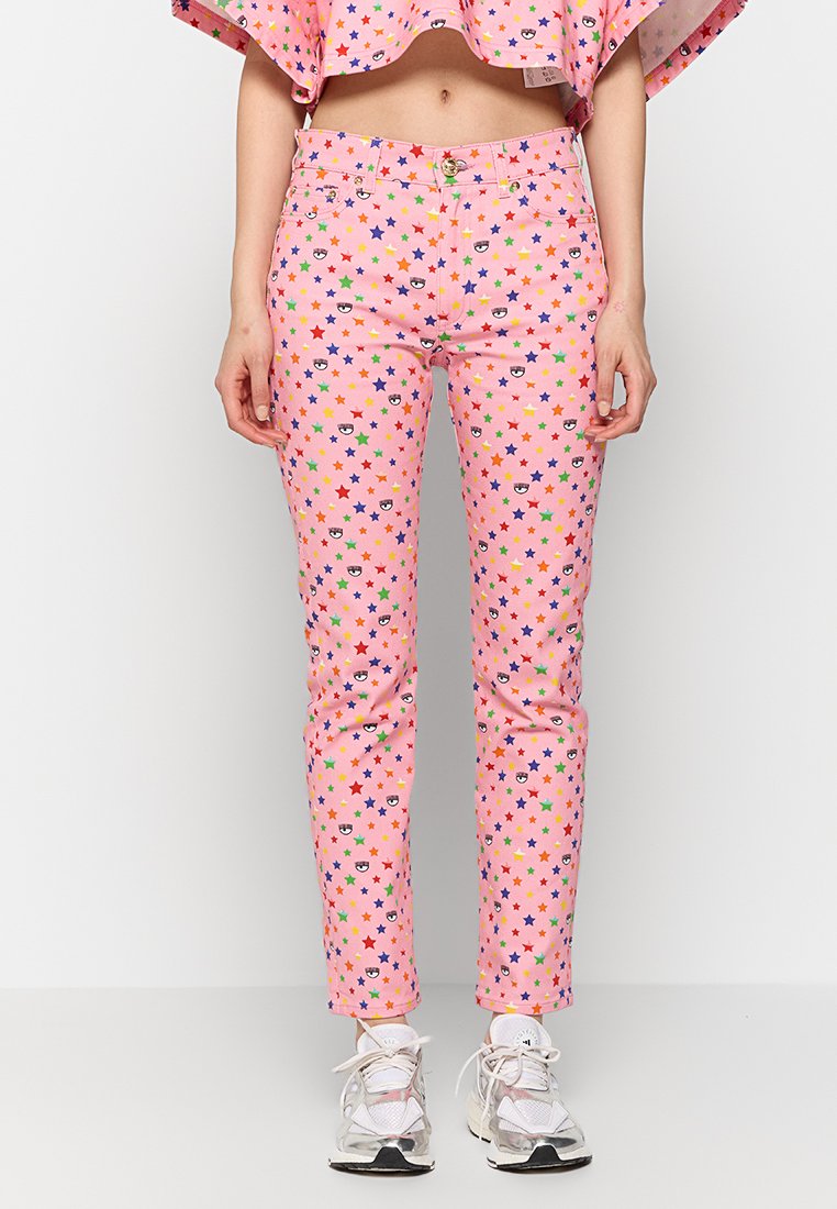 Pantalons en coton rose avec un motif d'étoiles de différentes couleurs. Coupe fuselée avec une fermeture à bouton et à glissière, accentués par des motifs ludiques.
