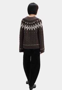 Maglione marrone a maglia grossa con una giogaia decorata in bianco e grigio, con scollatura ampia, maniche lunghe e vestibilità morbida.