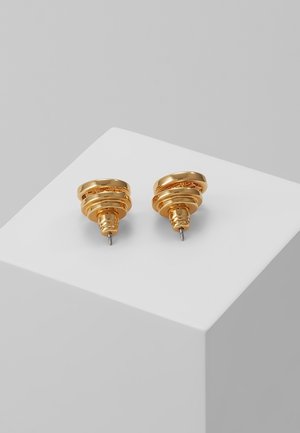 Paar glanzende goudkleurige gelaagde oorringen met stekers, gepresenteerd op een witte sokkel tegen een grijze achtergrond.