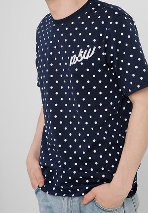 Granatowa koszulka z białymi kropkami, okrągły dekolt, krótkie rękawy, z haftowanym logo na piersi, wykonana z miękkiego materiału.