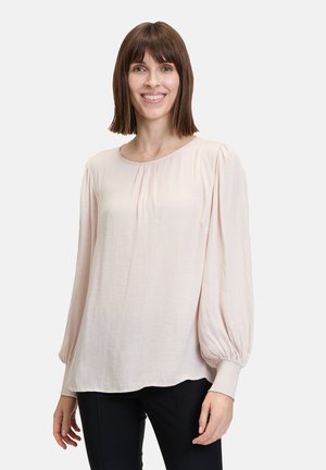 Helle rosa Bluse mit langen, puffartigen Ärmeln und einem gerafften Ausschnitt. Weicher, leichter Stoff mit glatter Textur und lässiger Passform.