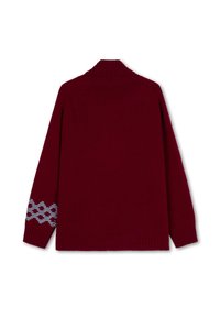 Bordeaux gebreide trui met een hoge kraag, geribde manchetten en een blauw geometrisch patroon op de linker mouw. Het materiaal lijkt zacht te zijn.