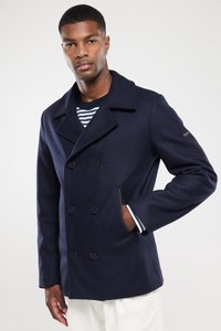 Granatowy dwurzędowy płaszcz typu peacoat z mieszanki wełny, z dużymi czarnymi guzikami, klapami oraz paskowanymi mankietami. Kieszeń z przodu po lewej stronie.