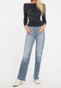 Gray off-the-shoulder fluffy sweater paired with light blue straight-leg jeans, featuring a classic five-pocket design and white sneakers.
