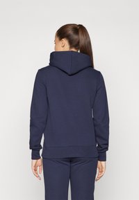 Felpa con cappuccio blu navy realizzata in materiale morbido, caratterizzata da una vestibilità comoda, polsini e orlo a costine, con una tasca a marsupio sul davanti.