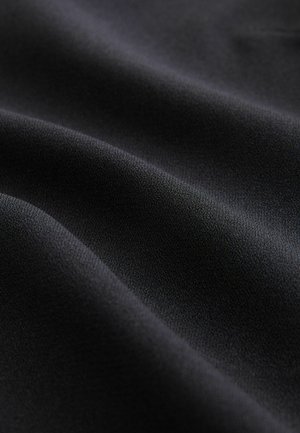 Tissu noir avec une texture lisse et mate et un éclat subtil, montrant des plis élégants et un tombé doux.