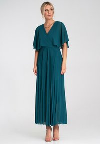 Turkusowa długa sukienka plisowana z falbaniastymi rękawami, dekoltem w serek i ściągniętym w talii. Wykonana z lekkiego materiału, o gładkiej fakturze, długości do kostek.