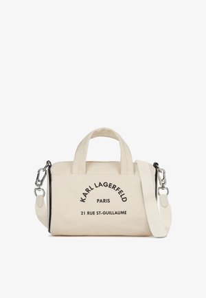 Canvas handbag in off-white with black print. Features dual handles and a detachable shoulder strap. Text includes brand and address details.