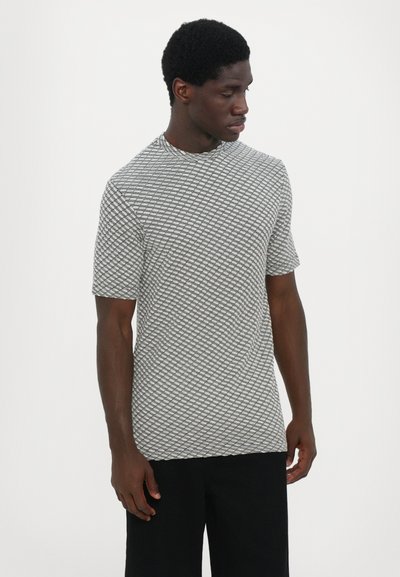 T-shirt à manches courtes et col haut, avec un motif géométrique en noir et blanc texturé. Fabriqué en tissu léger et respirant.