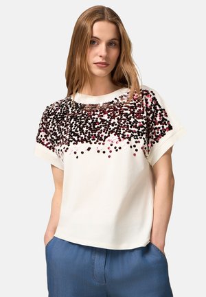 Weißes T-Shirt mit kurzen Ärmeln, das einen Verlauf aus rosa und schwarzen Pailletten über der Brust zeigt, mit entspannter Passform und Rundhalsausschnitt.