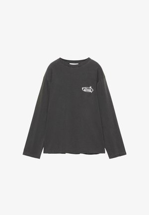 Chemise à manches longues gris foncé avec col rond, présentant un petit texte blanc "Moving Beyond" et un motif d'étoile sur le côté gauche de la poitrine.