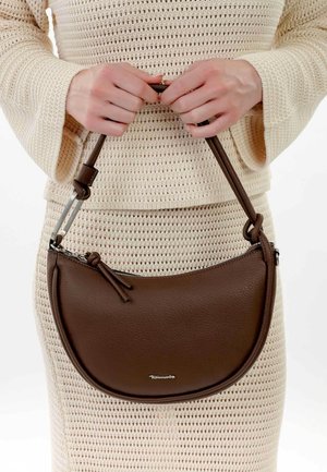 Brązowa skórzana torebka o zaokrąglonym kształcie, z zamkiem błyskawicznym i szczegółami w postaci frędzli. Z krótkim paskiem i metalowymi akcentami.