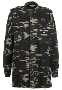 Giacca mimetica in verde scuro e nero, con due tasche frontali, spalline e scritta "SEASONS NO SEASON" sul petto.