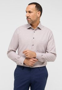 Licht geruite overhemd in beige met donkerblauwe knopen, met een kraag, een enkele borstzak en lange mouwen. Gekozen in combinatie met een marineblauwe broek.