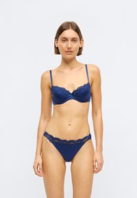 Tumši zila krūšturis ar mežģīņu apdari un atbilstoša uzvalka komplekts, ar regulējamiem siksniņām, gludu tekstūru un ziedu mežģīņu akcentiem malās.