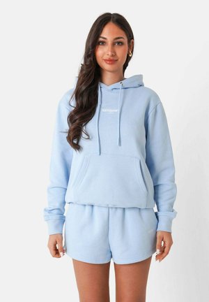 Un hoodie bleu clair avec une poche avant et une capuche à cordon, associé à un short assorti. Les deux vêtements présentent une texture douce en polaire.