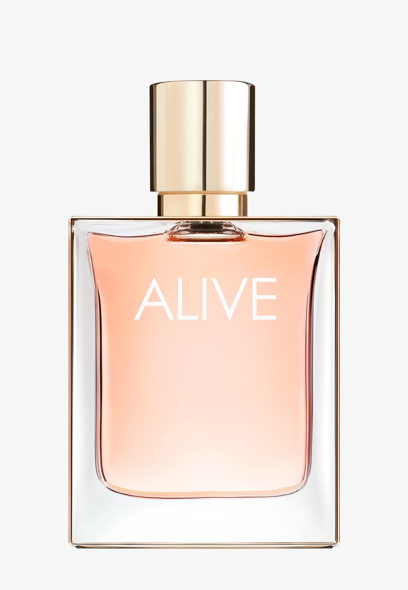 Flacon de parfum rectangulaire transparent avec liquide rose clair et bouchon doré, étiqueté « ALIVE » en texte blanc sur le devant.