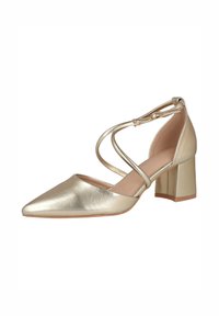 Zapato con tacón dorado metálico, punta puntiaguda, tiras cruzadas en el tobillo y tacón grueso tipo bloque. Textura lisa con detalles mínimos.