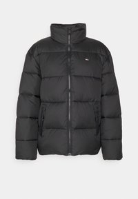 Black quilted puffer jacket with front zipper, two side pockets, and a small rectangular logo on the left chest.