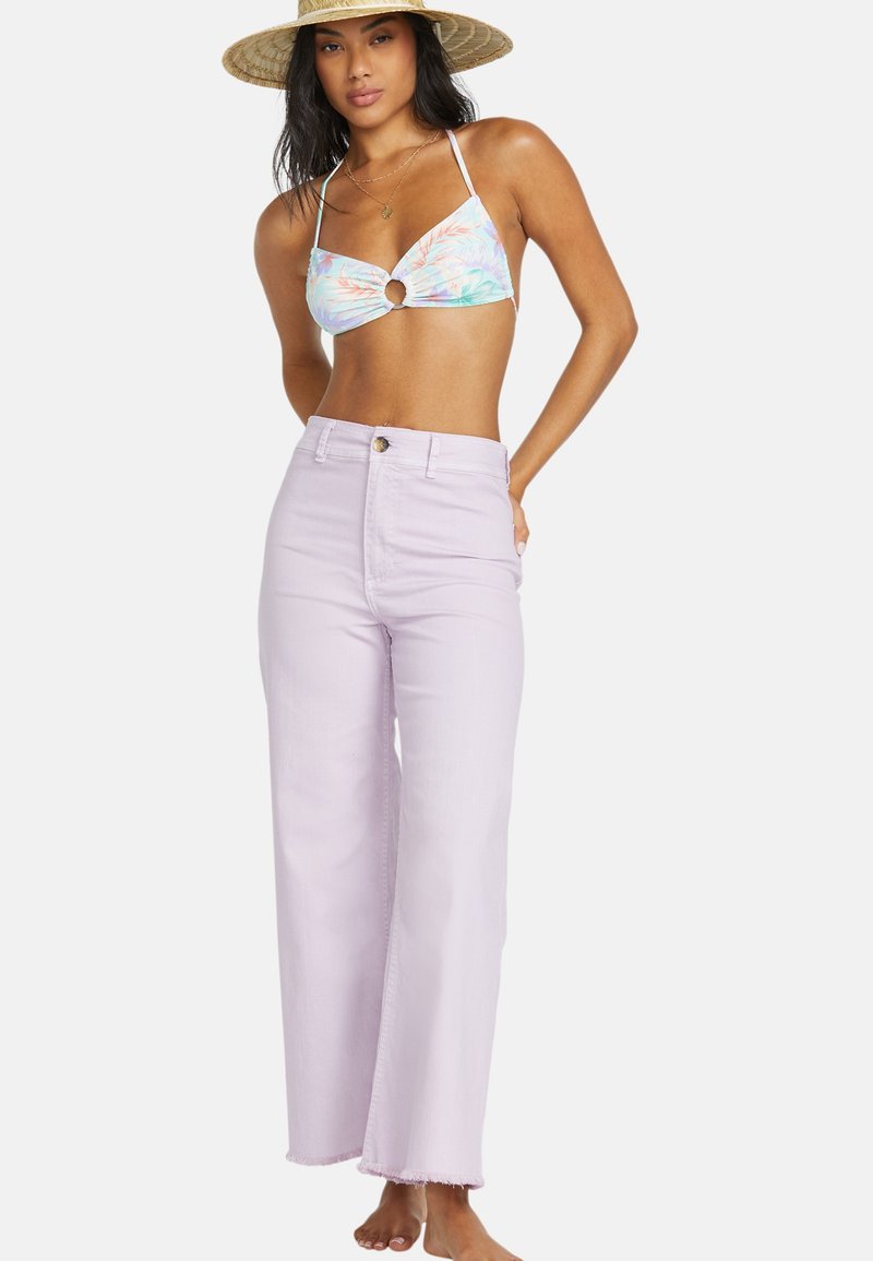 Lichtpaarse wijde jeans met een sluiting aan de voorkant en een ruwe zoom, gecombineerd met een meerkleurige bikini top met een ringdetail.