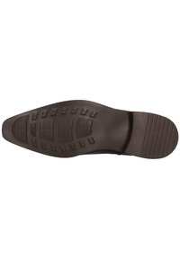 Suela de zapato de goma negra con patrones de textura y surcos para tracción, que presenta un tacón ligeramente elevado y un borde suave.