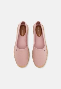 Pink canvas slip-on shoes with a textured finish and jute-style soles. Features a small logo accent near the toe area.