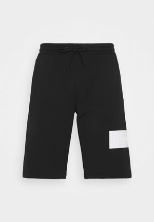 Pantaloncini neri in felpa realizzati in tessuto misto cotone, con vita elastica e coulisse e una toppa con logo bianco. Taglio standard.