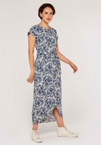 Maxikleid mit einem dunkelblauen und weißen Wellenmuster, kurzen umgeschlagenen Ärmeln und einem Bindegürtel. Es verfügt über einen seitlichen Schlitz und eine glatte Stofftextur.