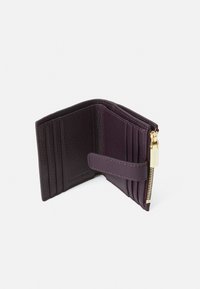 Dunkelviolettes Lederportemonnaie mit mehreren Kreditkartenfächern, einem Reißverschlussfach und einem Druckverschluss. Strukturierte Oberfläche und goldene Hardware-Akzente.