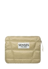 Beige gepolstertes Laptop Sleeve mit gesteppter Optik, ausgestattet mit einem schwarzen Etikett mit der Aufschrift „SENSES .THE LABEL.“ Reißverschluss auf einer Seite.