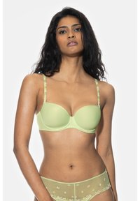 Vihreä pehmustettu rintaliivi, jossa on koristeelliset kukkastrapet, saumatön muotoilu ja sileä pinta. Tukeva alalanka ja vastaavat läpikuultavat laventeliväriiset alushousut.