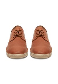 Hnědé kožené boty s texturovaným povrchem, kulatou špičkou a šněrovacím designem. Disponují kontrastní světlou gumovou podrážkou.